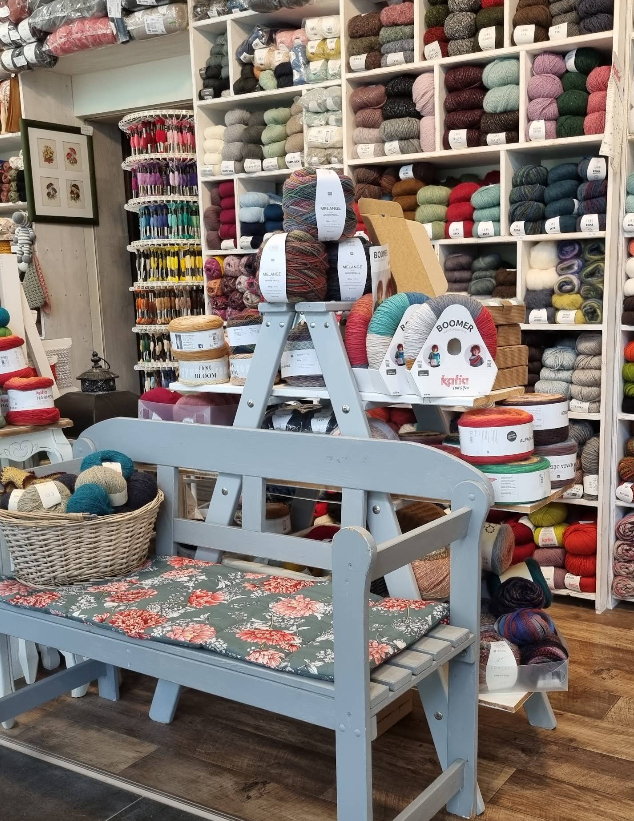 Wollregal und Holzbank mit Kissen im Laden Patchwork Handarbeit in Annaberg-Buchholz