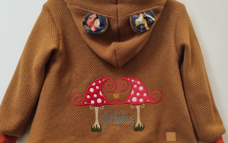 Braune Kinderjacke mit Fliegenpilz-Applikation aus dem Handarbeitsgeschäft in Annaberg-Buchholz
